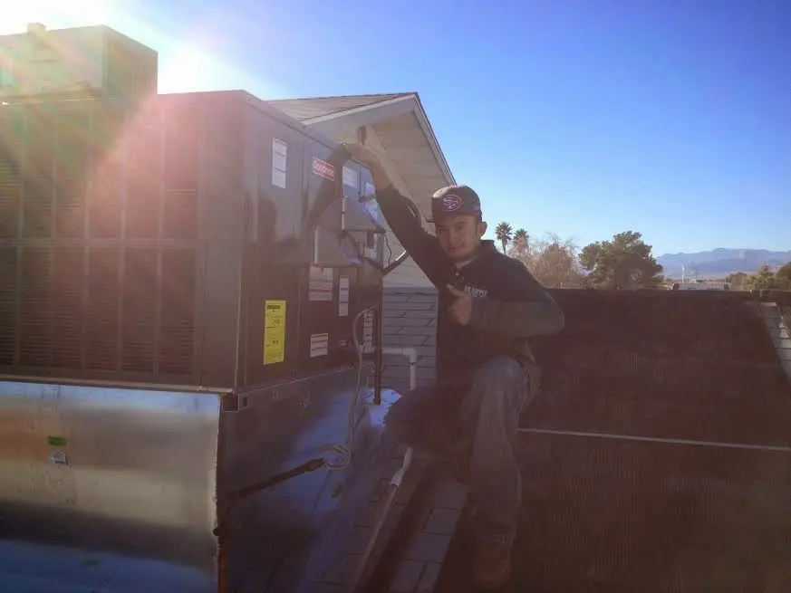 HVAC technician performing HVAC Inspection on a rooftop unit in Flossmoor